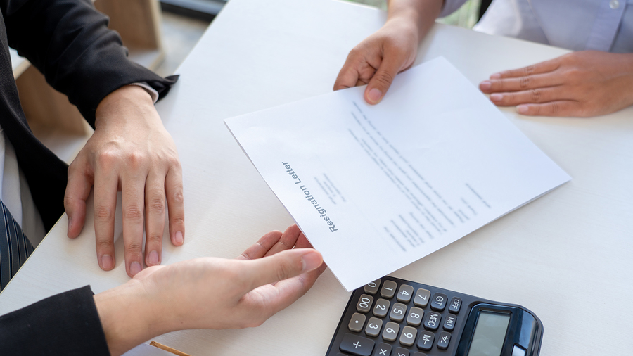 Tech job employee submitting a resignation letter to the executive employer boss on desk.