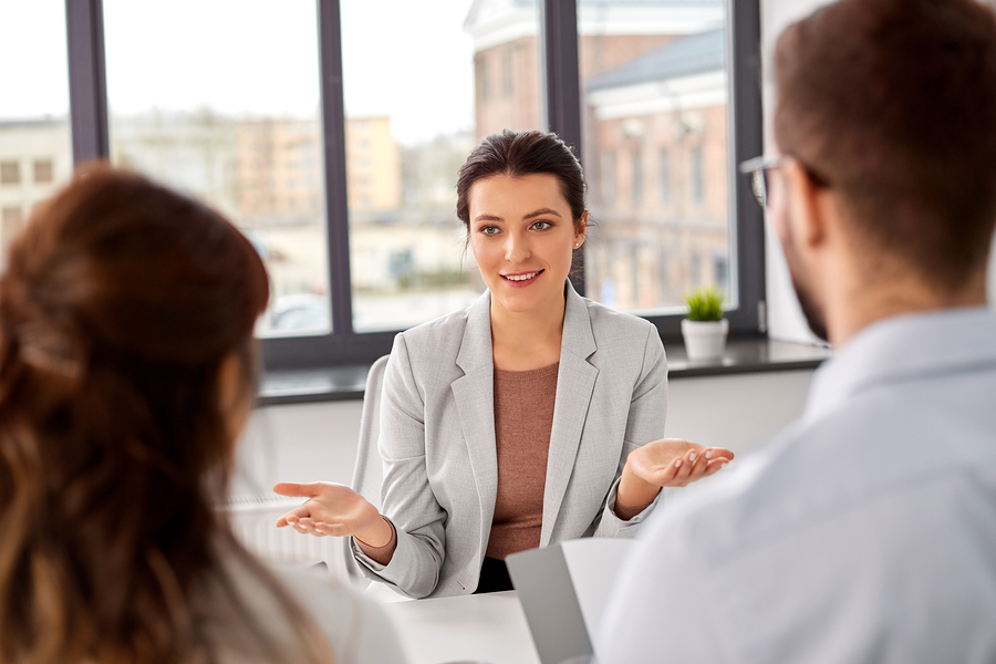 Tech staffing agency recruiters having interview with female employee at office.