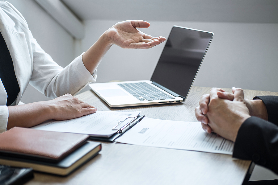 IT recruiter during a candidate profile while candidate holds resume.